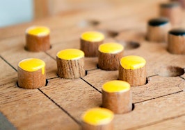 A game board with yellow and black pieces.