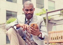 A young black man listening to something on his smartphone.