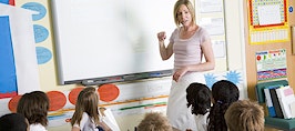 A teacher in front of a classroom of children