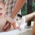 A baby being bathed in a basket outside