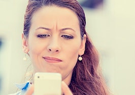 A woman looking skeptically at her phone.