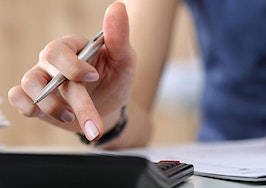 A woman accountant creating a budget using a calculator