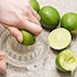 Two hands squeezing limes