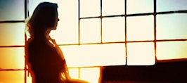 A woman working in a office, backlit by a window