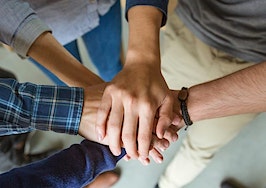A group of people with their hands atop each other
