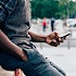 A millennial black man using a cell phone