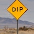 A sign on the road announcing a dip ahead