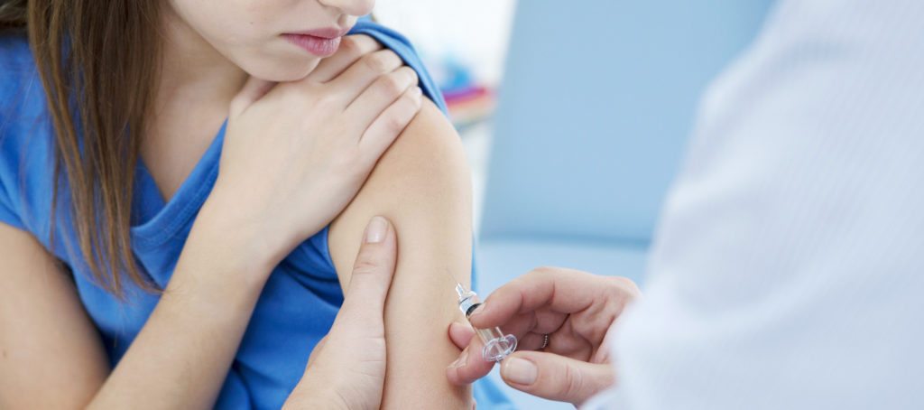 A young girl getting a shot in the arm