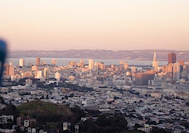 A sky-high view of San Francisco with binoculars in the foreground