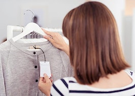 A woman checking a price tag on a shirt