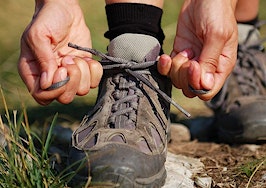 A woman lacing up her hiking boots for the trail