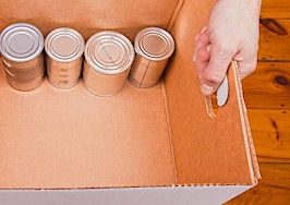 A pair of hands holding a box with cans