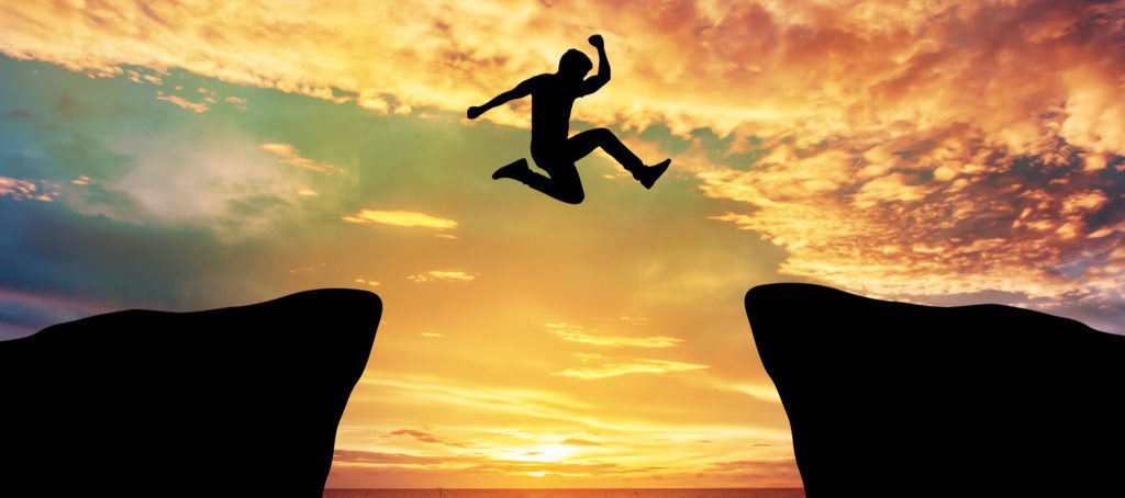 A man leaping between two hills