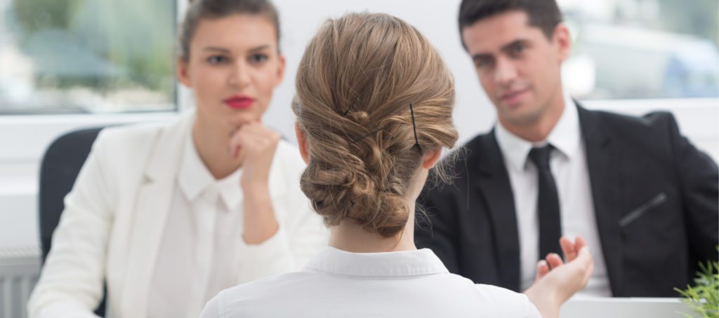 A man and woman interviewing a young woman