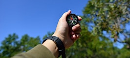 A man holding a compass in his hand
