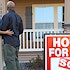 Homeowner couple in front of sold house