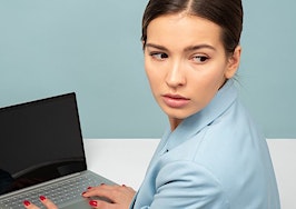 Woman looking worried sad over laptop computer