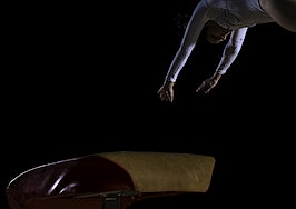 gynnast mid-flip from a vault