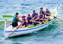 People rowing a boat out at sea