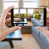 hands holding up smart phone to take a picture of a living room