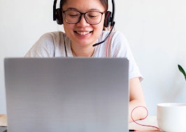 A young Southeast Asian woman doing freelance work at home using a laptop